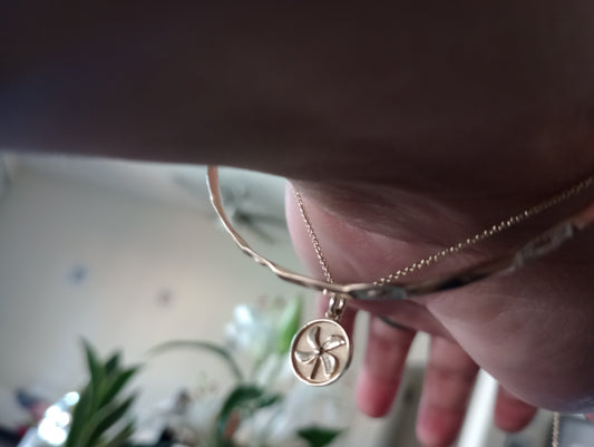 Gold Feels Like Fun® Pinwheel Pendant held in hand, showcasing its handcrafted circular design with symbolic spiral blades.